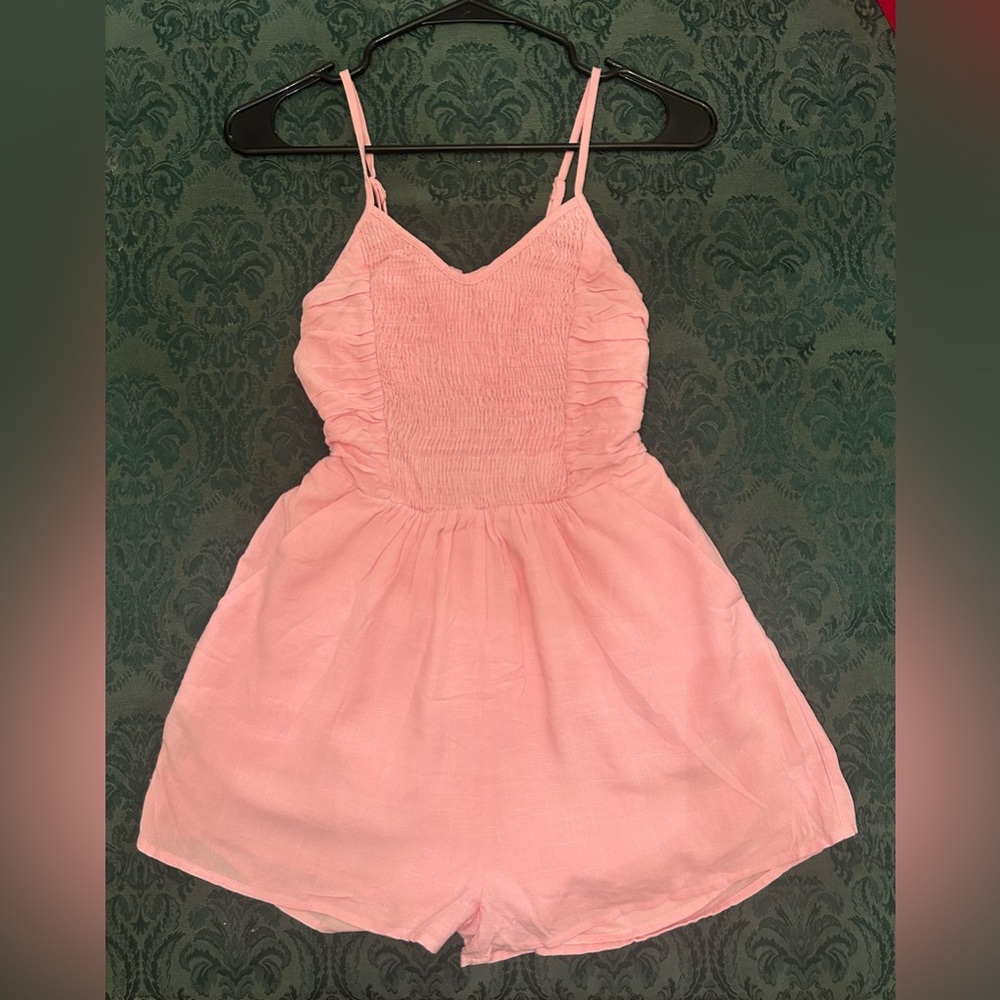 Woman’s light pink, open backed romper size Small.